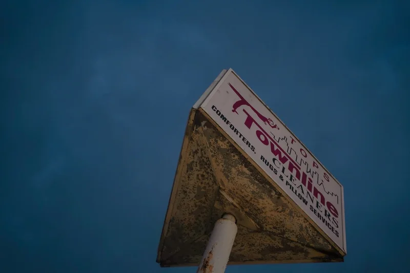 A weathered townline sign against a dark sky